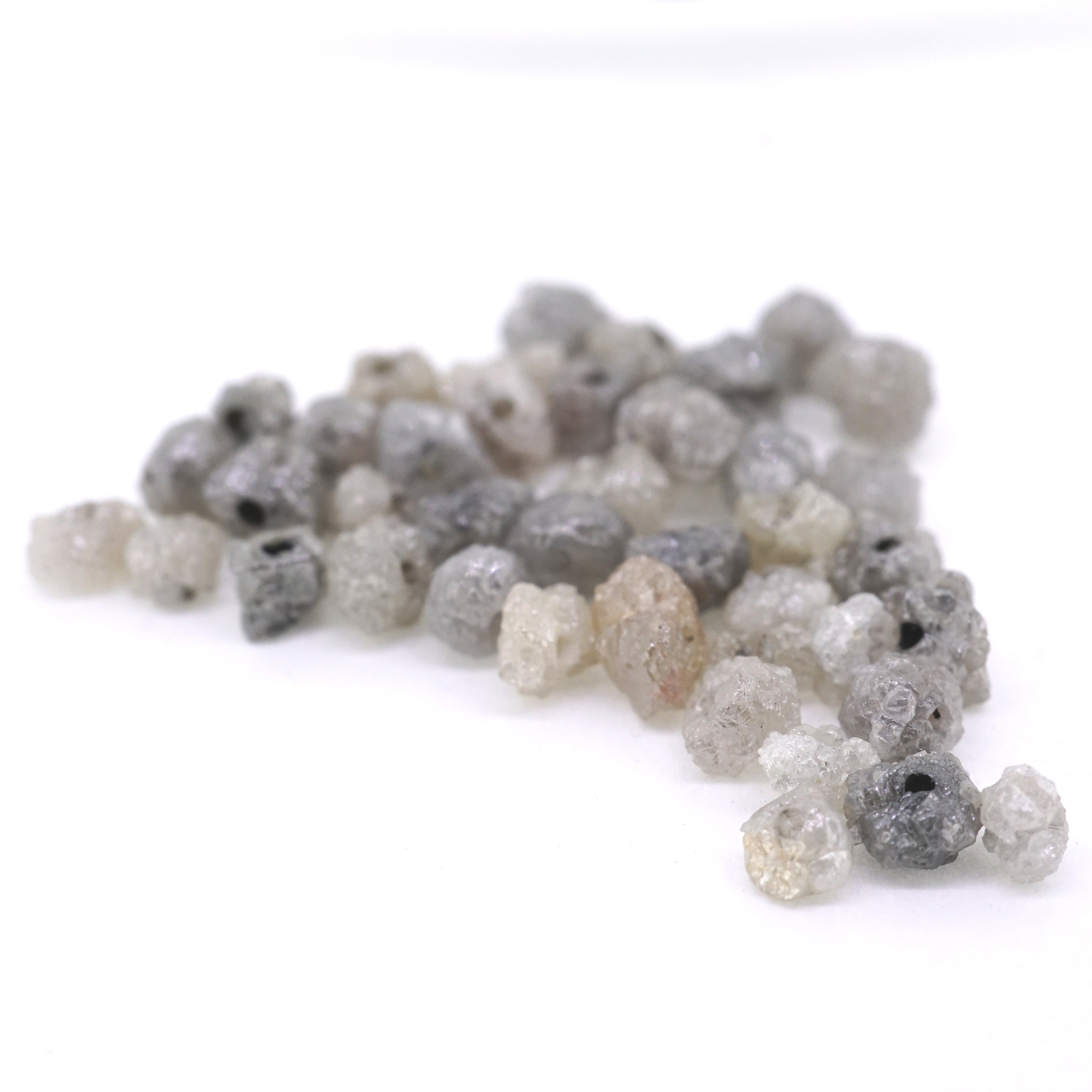 Rough diamonds in shades of grey laying in a pile